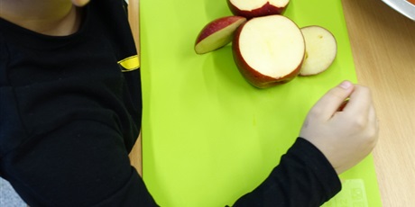 Powiększ grafikę: Chłopiec robi sowę z jabłek. Przed nim leży prawie gotowe dzieło.