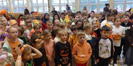 Powiększ grafikę: Sala gimnastyczna wypełniona dziećmi przebranymi w stroje nawiązujące do dyni.