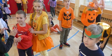 Powiększ grafikę: Dzieci ubrane na pomarańczowo, w stroje dyni.