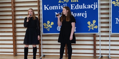 Powiększ grafikę: Dwie dziewczynki występują, w dłoniach mają mikrofony, śpiewają.