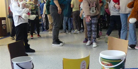 Powiększ grafikę: Dziewczynka rzuca piłką do wiaderka z napisem Miód.