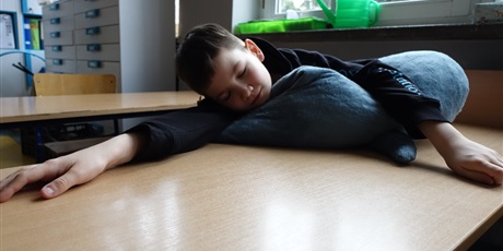 Powiększ grafikę: Chłopiec leży na poduszce, ma zamknięte oczy.