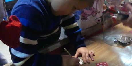 Powiększ grafikę: Stoisko kiermaszowe - widać jak chłopiec zdrapuje los.