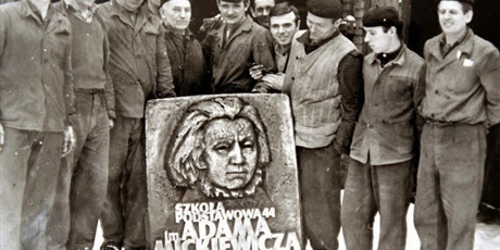 robotnicy stojący za tablicą z A. Mickiewiczem
